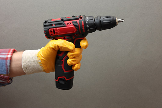 Electric Screwdriver being hold by a hand wearing gloves