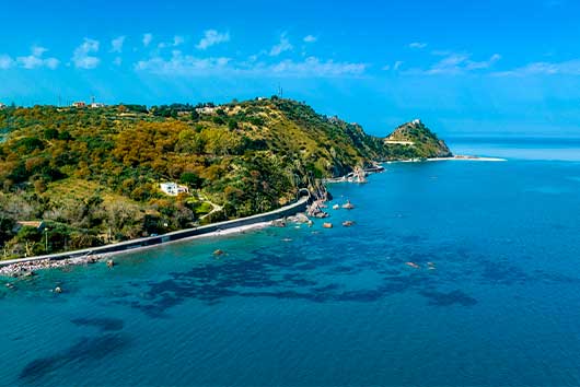 Scenic coast featuring a quaint town by the sea, with vibrant architecture and gentle waves.