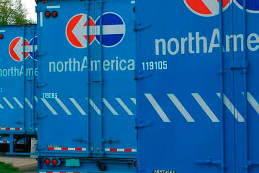 A line of blue trucks parked on a street, indicating a move from San Diego to Nashville, TN.
