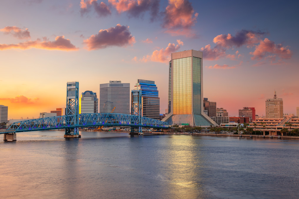 Jacksonville, Florida, USA. Cityscape image of Jacksonville, Florida with reflection of the city skyline in the water at beautiful sunset.